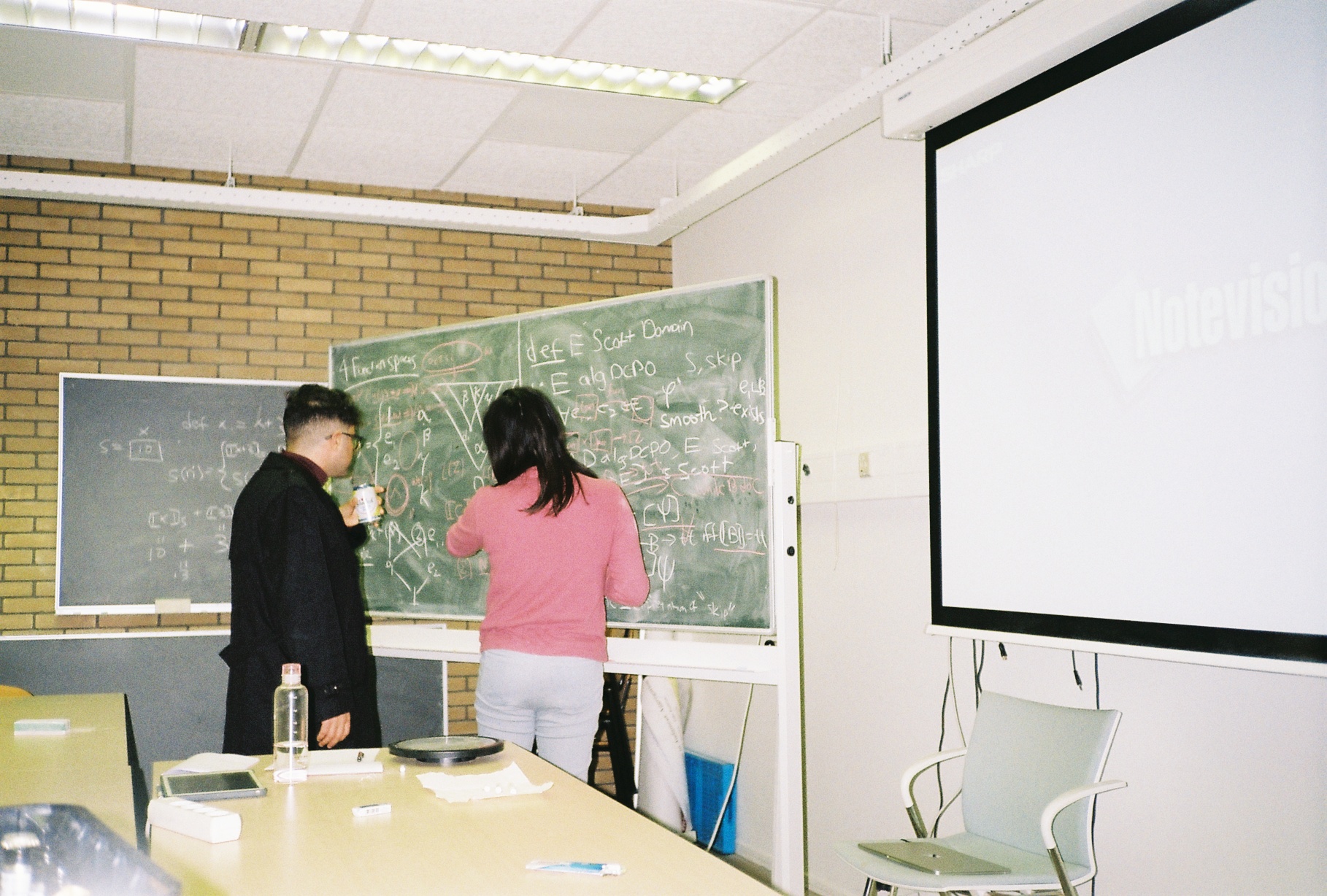 Alyssa and Rodrigo looking at a blackboard